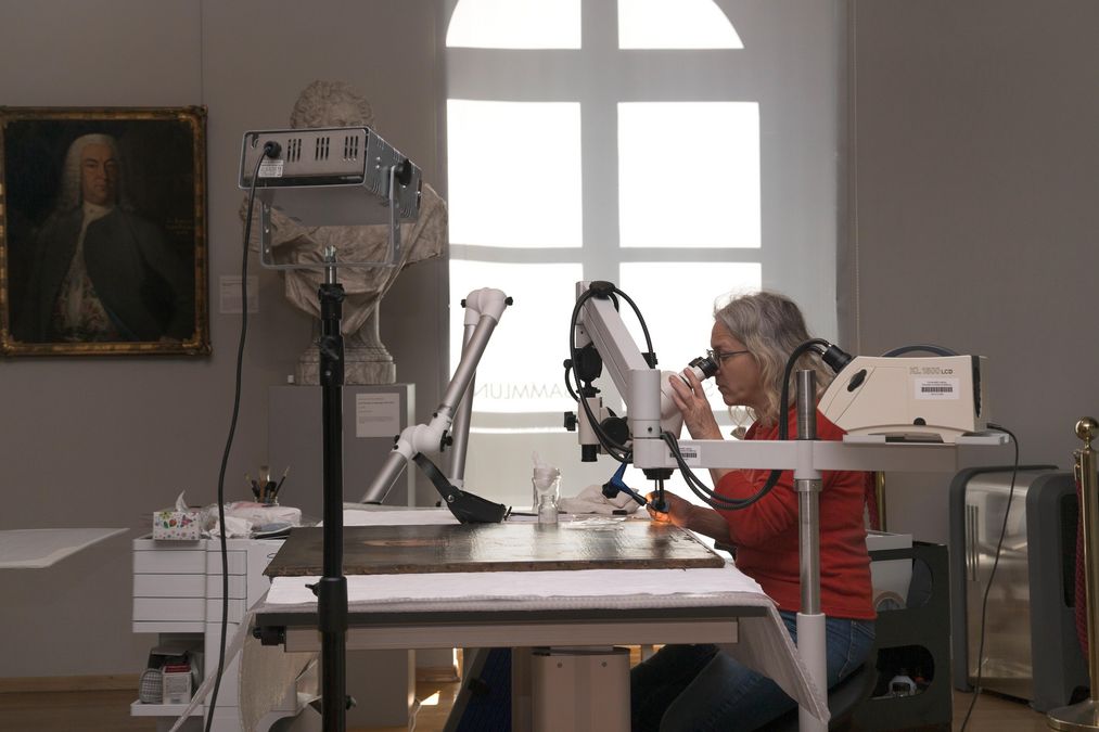 zur Vergrößerungsansicht des Bildes: Die Restauratorin Claudia Nicolaisen-Luckenbach arbeitet an einem Werk mittels Mikroskop