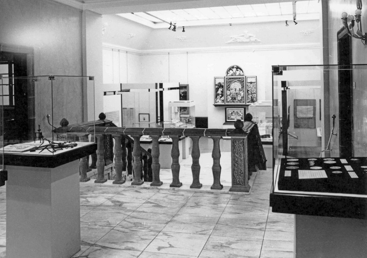 Schwarz-weiß-Foto aus dem Ausstellungsarchiv, Blick in das Ausstellungszentrum Kroch-Haus, im Oberlichtsaal sind eine Reihe von Kunstobjekten, Skulpturen und Gemälde aus der Zeit der Reformation, ausgestellt