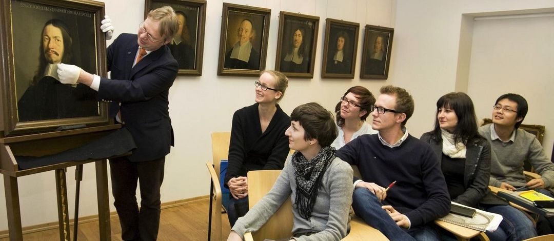 Studierende betrachten mit Prof. Dr. Hiller von Gaertringen ein Gemälde.