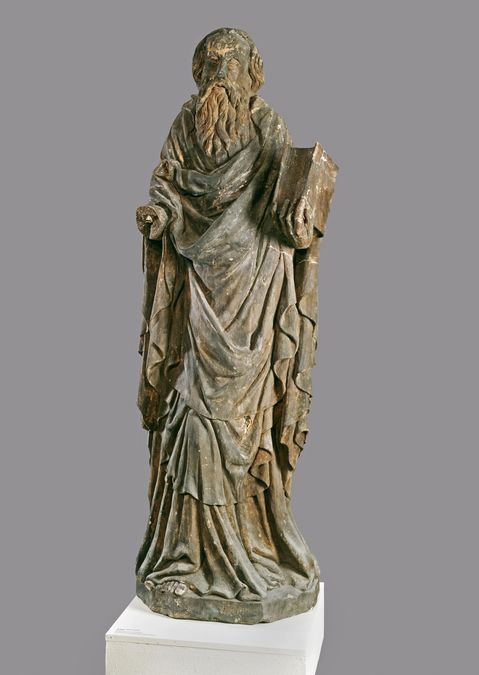 zur Vergrößerungsansicht des Bildes: Die gedunkelte Sandsteinfigur zeigt den Heiligen Paulus mit einem Buch in der linken Hand, die recht Hand fehlt.