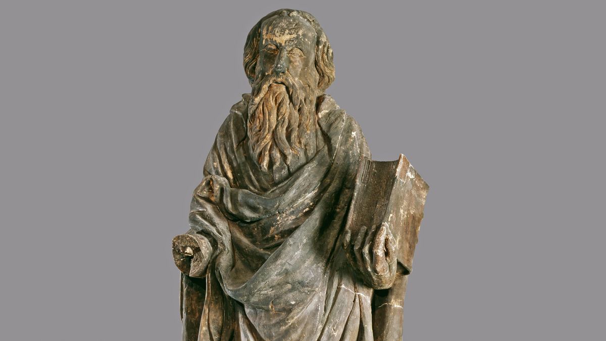 Die gedunkelte Sandsteinfigur zeigt den Heiligen Paulus mit einem Buch in der linken Hand, die recht Hand fehlt.